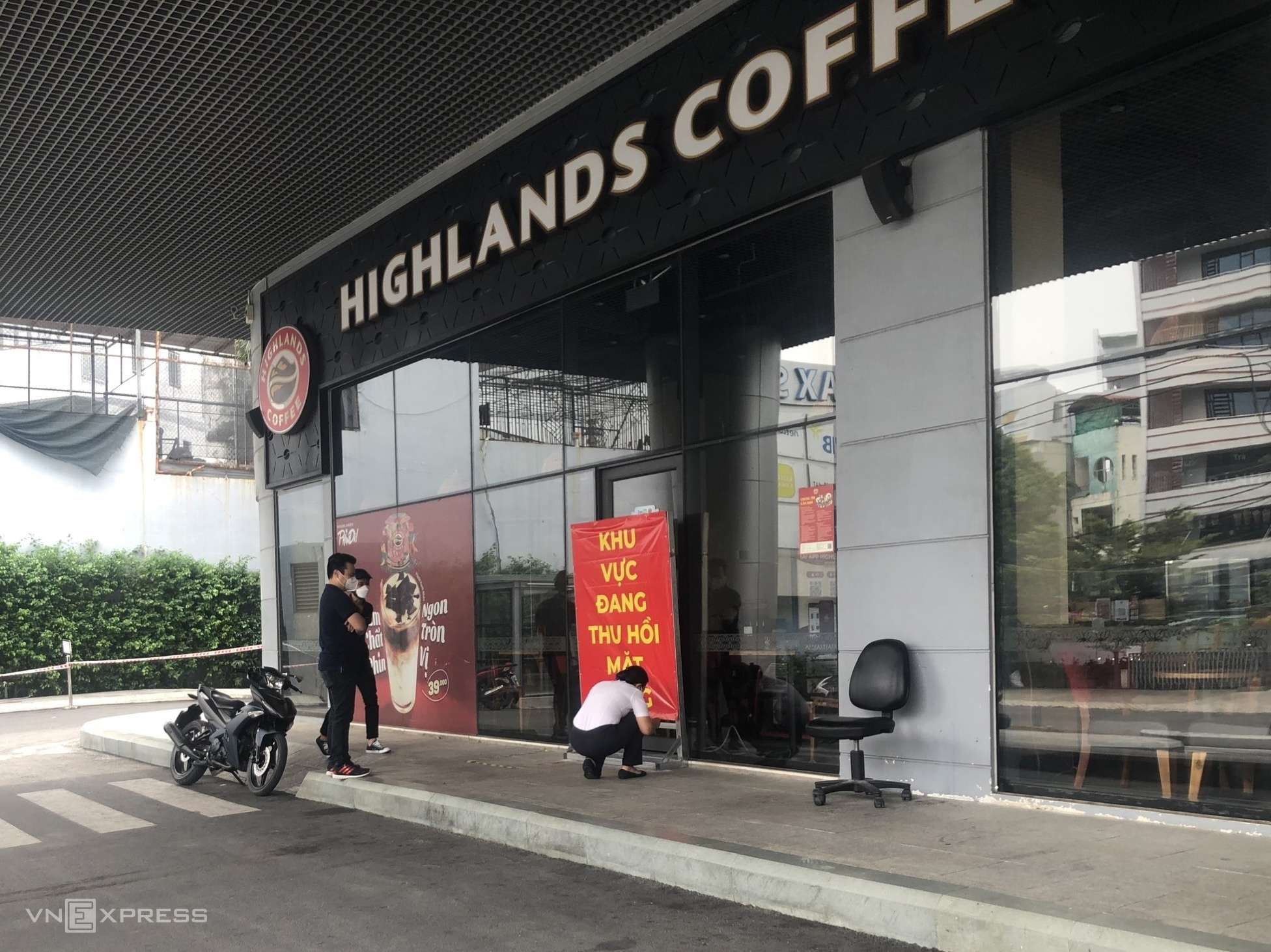 Nhân viên Highlands Coffee (hai người mặt áo đen) đến chứng kiến Nhà Hòa Bình niêm phong mặt bằng, sáng 29/11. Ảnh: Doanh nghiệp cung cấp