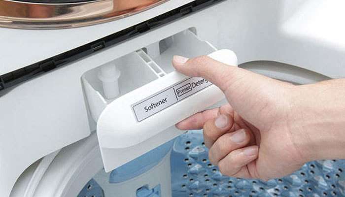 Đổ bột giặt/nước xả vào khay đựng chuyên dụng của máy giặt.
